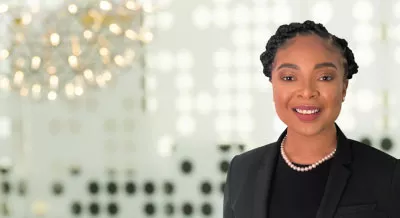 Headshot of Naprisha Taylor off center with blurry background 